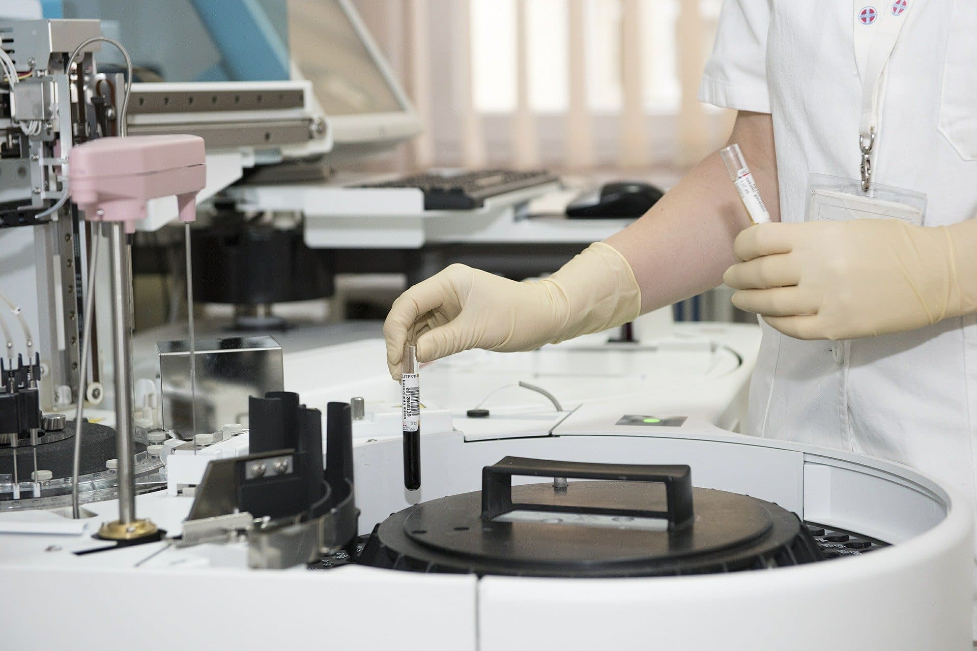Een buisje bloed gaat in het laboratoriumapparaat voor onderzoek.