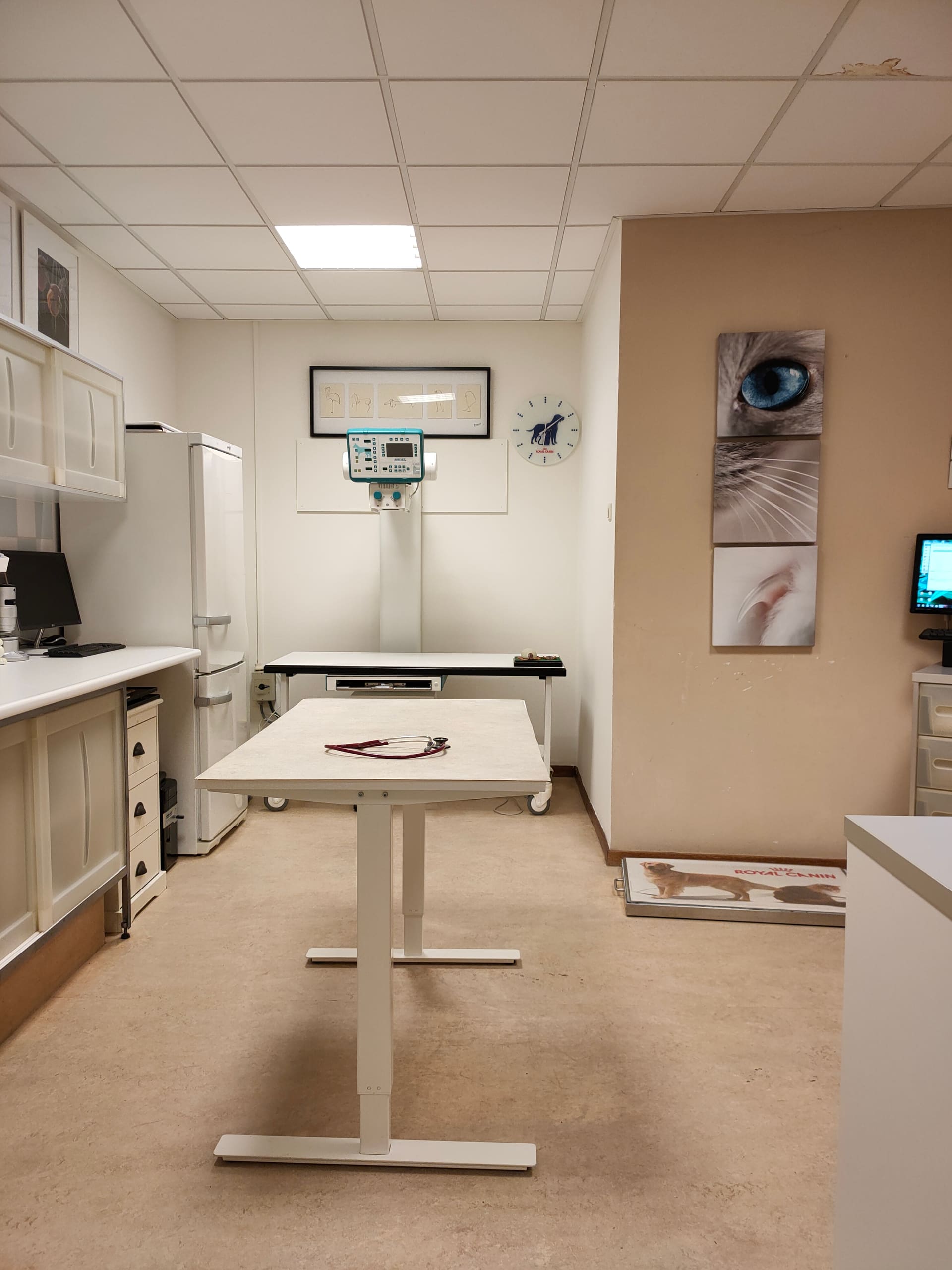 Behandelkamer met onderzoekstafel, stethoscoop en het röntgenapparaat.